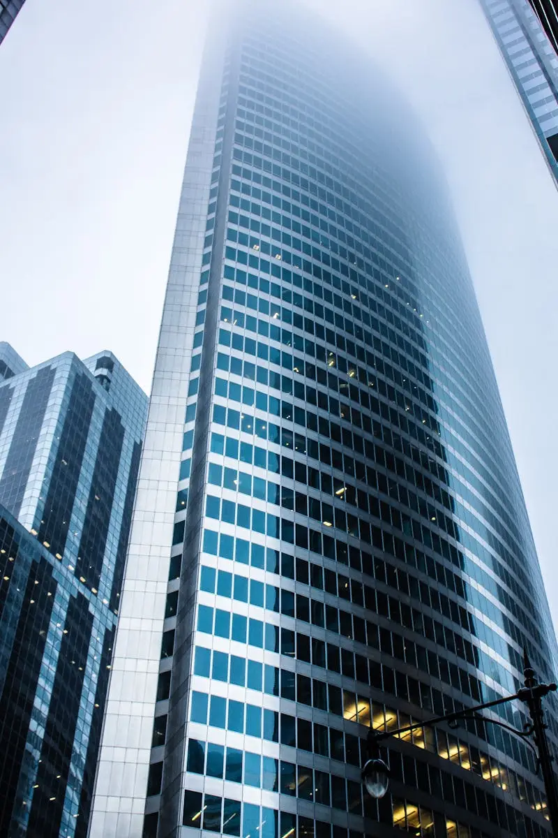 Dramatic view of modern skyscrapers shrouded in fog in an urban cityscape.